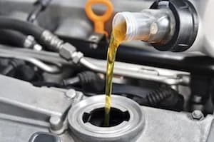 Fresh oil being poured during an engine service